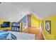 Finished attic room with pitched ceiling, bright yellow walls, and hardwood floors at 528 1St Nw Ave, Hickory, NC 28601