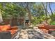 Stone patio with outdoor fireplace and seating, surrounded by lush landscaping at 528 1St Nw Ave, Hickory, NC 28601