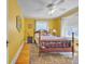 Yellow bedroom with a wooden bed frame, ceiling fan, hardwood floors and geometric area rug at 528 1St Nw Ave, Hickory, NC 28601