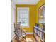 Sunny bedroom with wood floors, a rocking chair, and a bookshelf under a window with blinds at 528 1St Nw Ave, Hickory, NC 28601