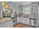 Well-lit kitchen with stainless steel appliances, tile backsplash, and hardwood floors at 528 1St Nw Ave, Hickory, NC 28601