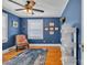 Blue office with hardwood floors features a ceiling fan, white shelving, a rug and framed award certificates at 528 1St Nw Ave, Hickory, NC 28601