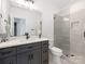 Modern bathroom featuring a glass shower, gray vanity, and black hardware fixtures at 5511 Fairview Rd, Charlotte, NC 28209