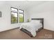 Bedroom with neutral carpet, white walls, and a gray upholstered bed near the windows at 5511 Fairview Rd, Charlotte, NC 28209