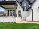 Charming front entrance with a covered porch, rocking chairs, white brick, and a beautifully landscaped lawn at 5511 Fairview Rd, Charlotte, NC 28209