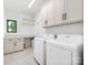 Bright laundry room featuring white cabinetry, a countertop, a front-load washer and dryer at 5511 Fairview Rd, Charlotte, NC 28209