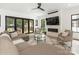 Bright living room featuring a fireplace, hardwood floors, large windows, and access to outdoor patio at 5511 Fairview Rd, Charlotte, NC 28209