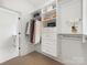 A white walk-in closet with shelving, drawers, hanging racks, and hardwood floors at 5511 Fairview Rd, Charlotte, NC 28209