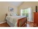 Bedroom with hardwood floors, neutral walls, a queen bed, and large window at 6311 Ridge Path Ln, Charlotte, NC 28269