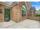 Close-up of a brick and siding house, highlighted by a green front door and a concrete patio at 6311 Ridge Path Ln, Charlotte, NC 28269