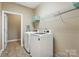Bright laundry room features tile floor, neutral walls, and new white front load washer and dryer at 6311 Ridge Path Ln, Charlotte, NC 28269