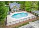 An aerial view showcases a community pool enclosed by a black fence and surrounded by lush greenery at 6311 Ridge Path Ln, Charlotte, NC 28269