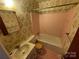 Vintage-style bathroom with pink tile, floral wallpaper, and classic fixtures, offers nostalgic charm at 729 Aintree Rd, Charlotte, NC 28215