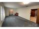 View of the living room with neutral paint, carpeting, and transition to an adjacent space, highlighting the home's layout at 729 Aintree Rd, Charlotte, NC 28215