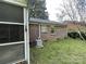 Brick home featuring a well-maintained backyard with mature trees and a dedicated space for the HVAC system at 729 Aintree Rd, Charlotte, NC 28215