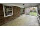 Enclosed sunroom featuring brick walls, concrete floor, and screen windows, perfect for enjoying the outdoors year-round at 729 Aintree Rd, Charlotte, NC 28215