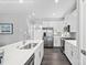 Modern kitchen featuring white cabinets, stainless steel appliances, and a large island with a sink at 7349 Childress Sw Dr, Concord, NC 28025