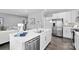Modern kitchen featuring white cabinets, stainless steel appliances, and a large island with a sink at 7349 Childress Sw Dr, Concord, NC 28025
