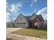 Charming home featuring a two-car garage, stone accents, and a well-manicured lawn at 740 Rosegate Dr, Gastonia, NC 28056