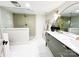 Bright bathroom with a glass shower, dual sink vanity with gold fixtures, and white tile flooring at 7507 Limerick Dr, Charlotte, NC 28270