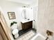 Well-lit bathroom showcasing a dark wood vanity, an oval mirror, a toilet and a patterned floor at 7507 Limerick Dr, Charlotte, NC 28270