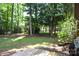 Spacious backyard with mature trees, visible from a wooden deck, offering a private outdoor setting at 8807 Tree Haven Dr, Charlotte, NC 28270