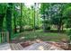 Overlooking a spacious yard featuring lush greenery and a wood deck at 8807 Tree Haven Dr, Charlotte, NC 28270