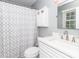 Bathroom with white vanity, silver faucet, framed mirror, and patterned shower curtain at 8807 Tree Haven Dr, Charlotte, NC 28270