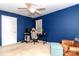A stylish bedroom featuring blue walls, a modern desk, and a comfortable gaming chair at 8807 Tree Haven Dr, Charlotte, NC 28270