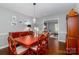 Traditional dining room with hardwood floors, cherry wood table and chairs, and views into the living room at 8807 Tree Haven Dr, Charlotte, NC 28270