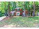 Classic two-story brick home surrounded by mature trees and a green lawn, offering a serene setting at 8807 Tree Haven Dr, Charlotte, NC 28270