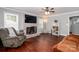 Cozy living room featuring hardwood floors, a brick fireplace, and a comfortable seating arrangement at 8807 Tree Haven Dr, Charlotte, NC 28270