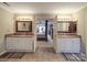 A bathroom with double vanities and sinks that leads into the main bedroom with a stylish bed at 9001 Fenwick Dr, Indian Trail, NC 28079