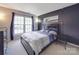 Bedroom featuring a large window, dark accent wall, dresser, and a sleek modern bedframe at 9001 Fenwick Dr, Indian Trail, NC 28079