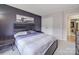 Bedroom featuring a large window, dark accent wall, dresser, and a sleek modern bedframe at 9001 Fenwick Dr, Indian Trail, NC 28079