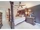 A main bedroom featuring a stylish four-poster bed, a ceiling fan, and dark accent wall at 9001 Fenwick Dr, Indian Trail, NC 28079