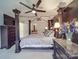 A main bedroom featuring a stylish four-poster bed, a ceiling fan, and dark accent wall at 9001 Fenwick Dr, Indian Trail, NC 28079