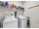 Functional laundry room with washer, dryer, shelving, and a peg rack at 9077 Myrna Dr, Gastonia, NC 28056