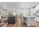 Open-concept living space boasts hardwood floors and a modern kitchen with a large island and barstool seating at 9077 Myrna Dr, Gastonia, NC 28056