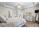 Spacious main bedroom with a tray ceiling, a ceiling fan, and a glimpse into the main bathroom at 9077 Myrna Dr, Gastonia, NC 28056