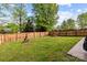 Large, well-maintained backyard featuring a wooden fence, swing, and picnic table, offering a private and serene outdoor space at 909 Jordans Pond Ln, Charlotte, NC 28214