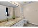 Bathroom featuring a double sink vanity with granite countertops, a soaking tub, and neutral paint at 909 Jordans Pond Ln, Charlotte, NC 28214