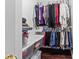 Walk-in closet with wood floor, white wire shelving, and rods for hanging clothes and storage containers at 909 Jordans Pond Ln, Charlotte, NC 28214