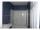 Bathroom with white tub and shower combination, dark blue walls, and a white door at 9109 Foggy Meadow Rd, Charlotte, NC 28269