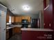 Kitchen with wood cabinets, black appliances, and peninsula for added counter space at 9109 Foggy Meadow Rd, Charlotte, NC 28269