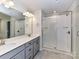 Bathroom featuring double sink vanity, large mirror and glass-enclosed shower with subway tile at 9134 Northfield Crossing Dr, Charlotte, NC 28269