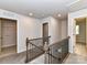 Upstairs hallway featuring neutral carpet, wood railing and access to multiple rooms at 9134 Northfield Crossing Dr, Charlotte, NC 28269