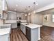 Open kitchen featuring gray cabinets, stainless steel appliances, a spacious island, and wood flooring at 9134 Northfield Crossing Dr, Charlotte, NC 28269