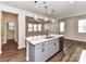 Bright open-concept kitchen with a center island, stainless appliances, and wood floors flowing into the living space at 9134 Northfield Crossing Dr, Charlotte, NC 28269