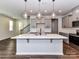 Modern kitchen with a large island, stylish pendant lighting, stainless steel appliances, and gray cabinets at 9134 Northfield Crossing Dr, Charlotte, NC 28269